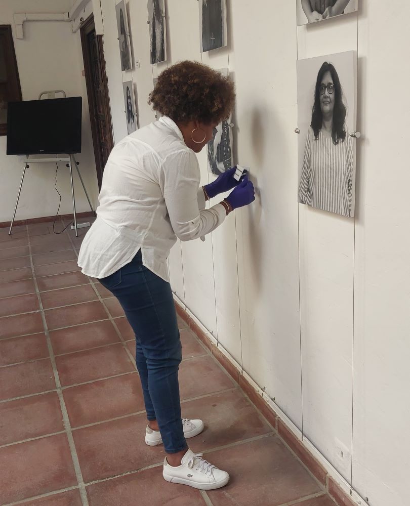 Montaje de una exposición con retratos de mujeres en un espacio cultural.