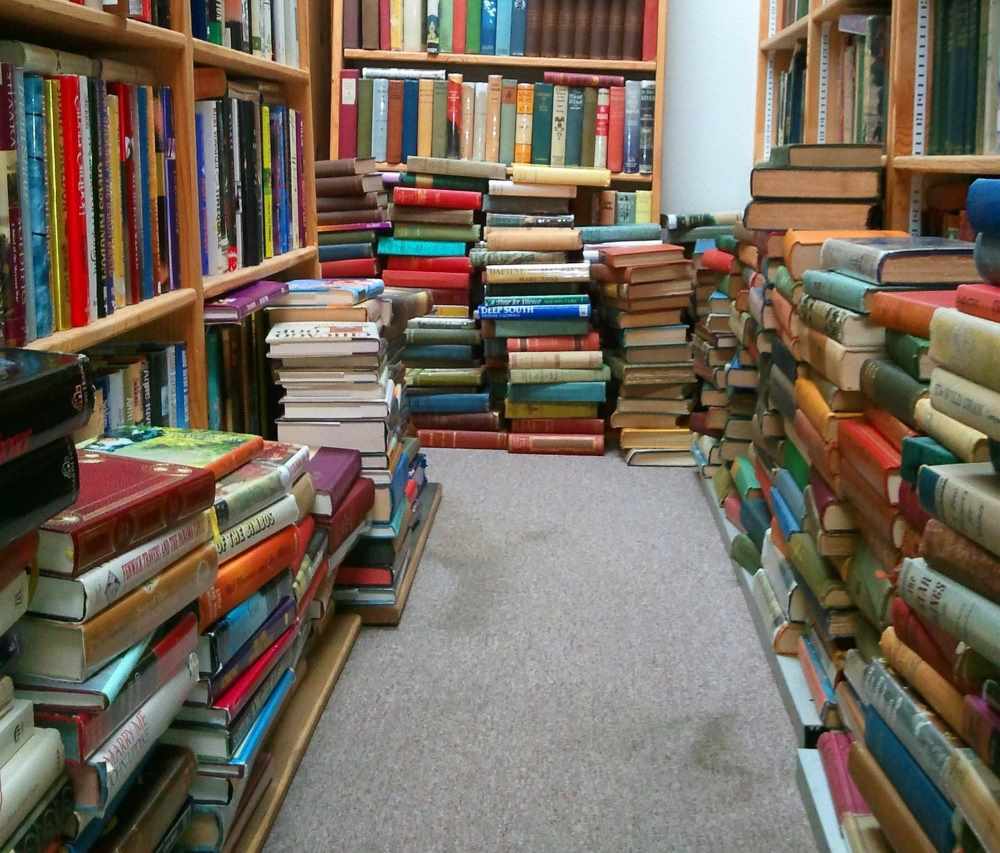 Multiples bloques libros por el suelo y estanterias