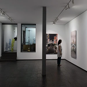 Visitante contempla pinturas de arte contemporáneo en una galería
