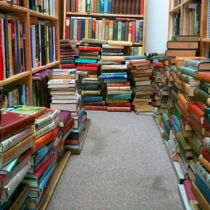Multiples bloques libros por el suelo y estanterias