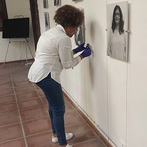 Montaje de una exposición con retratos de mujeres en un espacio cultural.