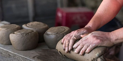 Manos de artesanos trabajando el barro