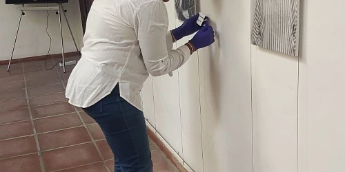 Montaje de una exposición con retratos de mujeres en un espacio cultural.