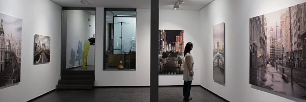 Visitante contempla pinturas de arte contemporáneo en una galería