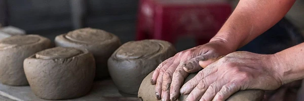 Manos de artesanos trabajando el barro