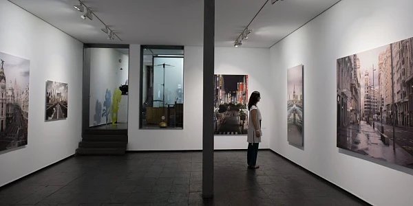 Visitante contempla pinturas de arte contemporáneo en una galería